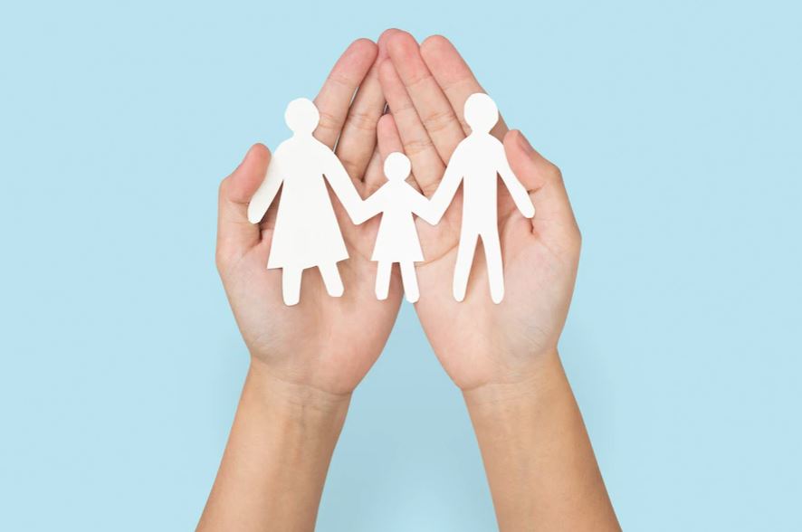 imagem de mão segurando família feita de dobradura de papel