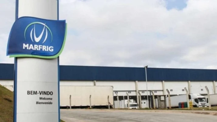 Logotipo da Marfrig em frente à uma unidade da empresa, representando a MRFG3.