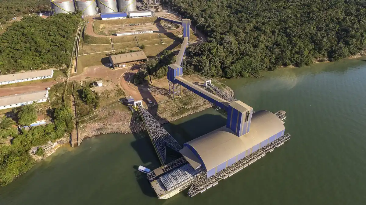 Comboio de barcaças rebocado por um empurrador navegando em um rio ou hidrovia, representando a operação de logística da Hidrovias do Brasil.