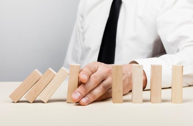 gestão de risco: foto de pesso segurando blocos de madeira