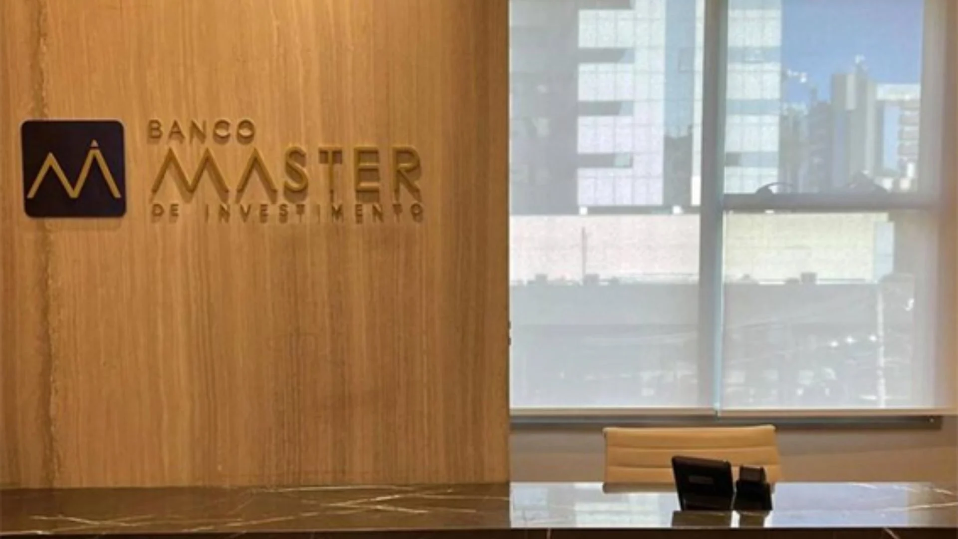 Sala de reunião do Banco Master com logo institucional em destaque na parede.
