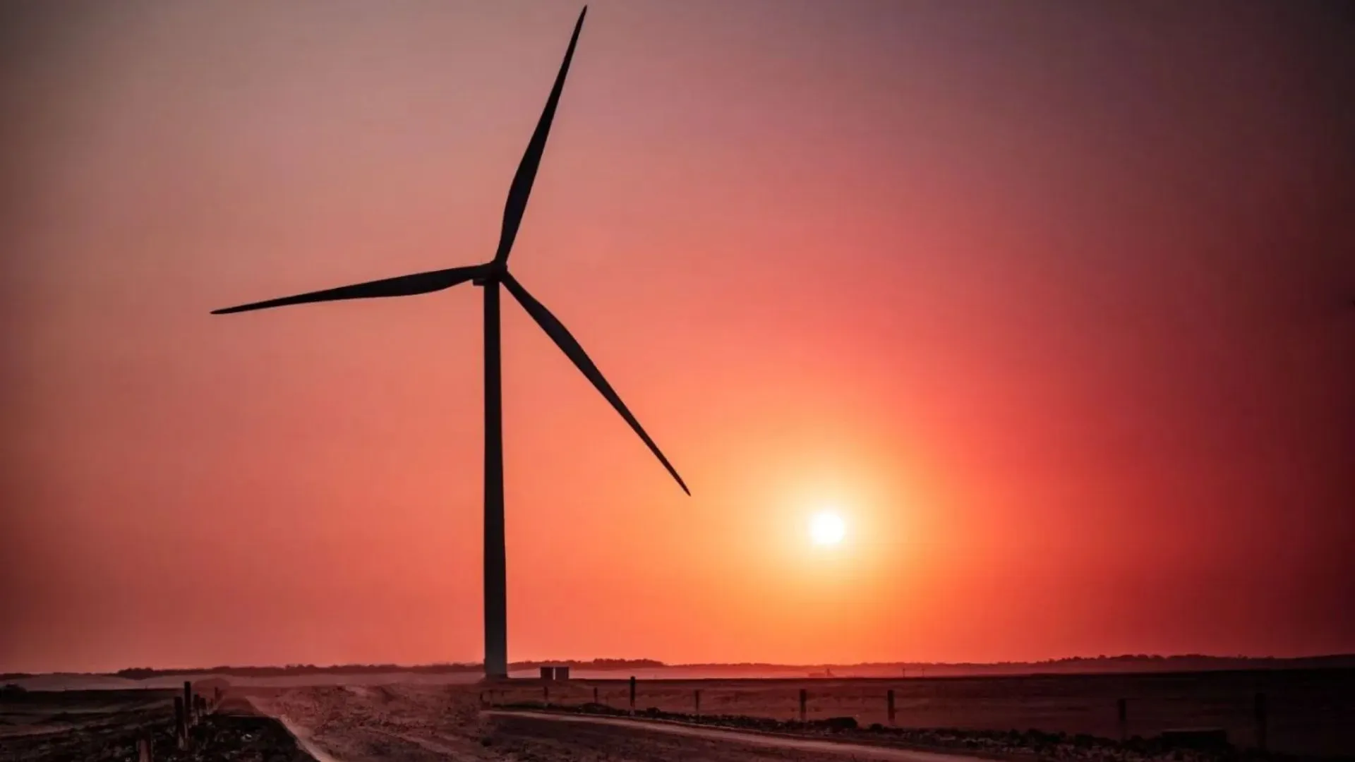 Turbina eólica da Serena Energia ao pôr do sol, representando o investimento da SRNA3 em energia renovável.