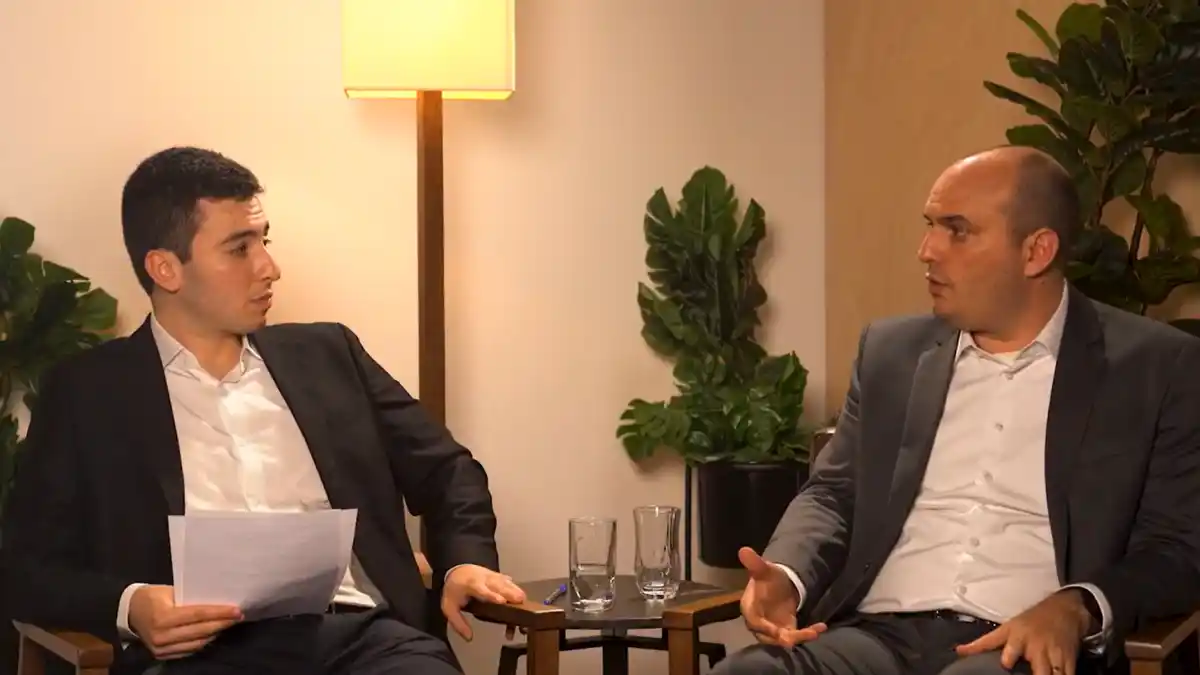 Dois homens em trajes de negócios em entrevista, discutindo o fundo de infraestrutura BODB11