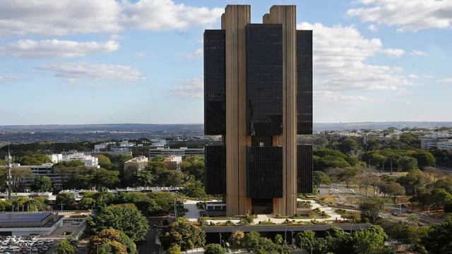 Vista aérea do Edifício-Sede do Banco Central do Brasil em Brasília, uma estrutura modernista de concreto e vidro, representando o local das decisões do Copom hoje.