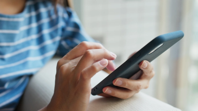 Mulher mexe em aparelho de celular como operado pela Vivo