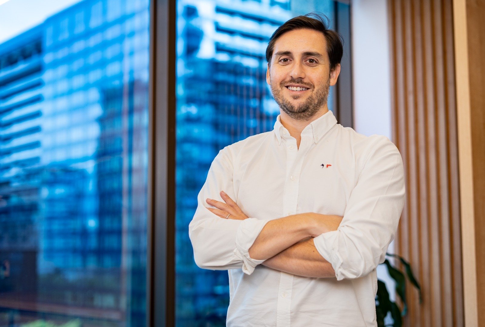Homem olhando para a câmera, de braços cruzados e sorrindo. Felipe Passaro