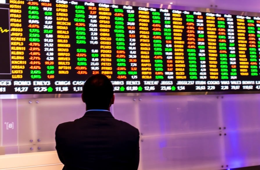 BOVA11: EQI Research recomenda compra. Imagem de homem analisando quadro de cotações na bolsa brasileira