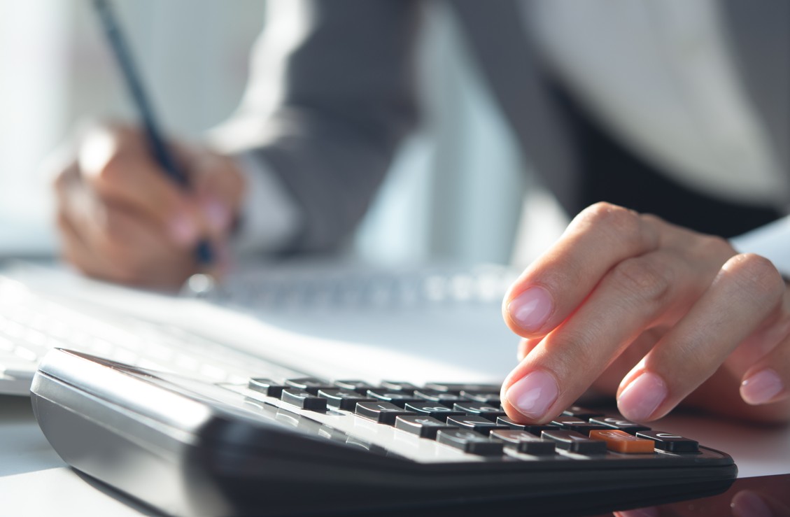 imposto de renda dos investimentos vai mudar: imagem de mão feminina usando calculadora